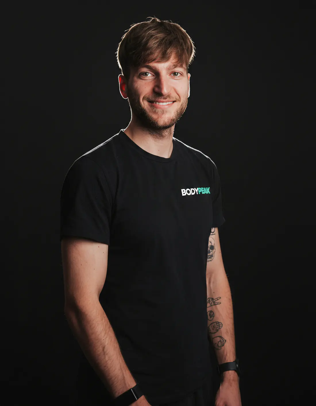 Studioportrait von Patrick Keicher im schwarzen BodyPeak-Shirt vor dunklem Hintergrund