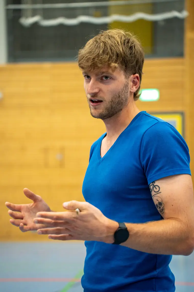 Patrick Keicher erklärt gestikulierend eine Übung in einer Sporthalle